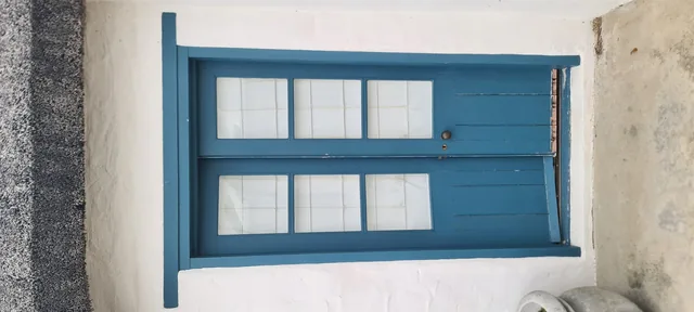 Blue cottage-pane aluminium window in a white wall