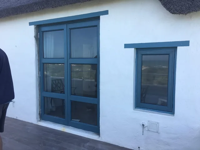 Cottage-pane aluminium window below a thatched roof