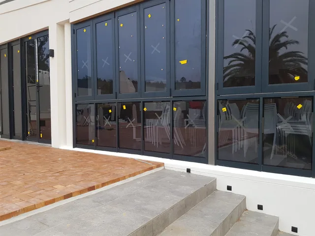 Dark aluminium shopfront-style window wall