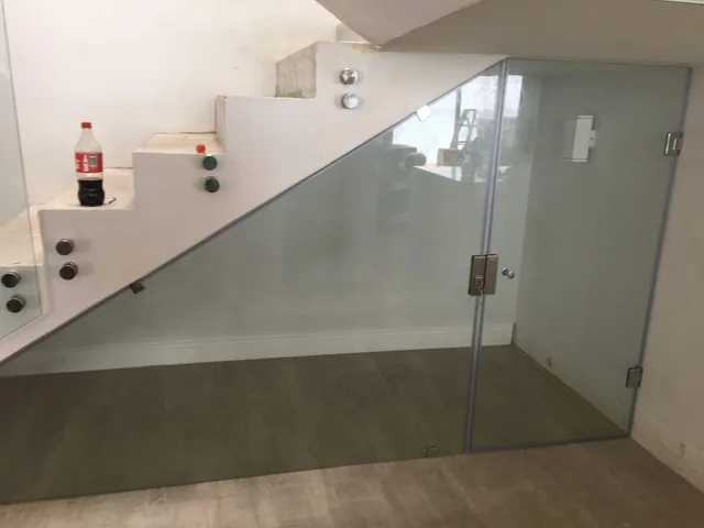 Frameless glass partition beside an interior staircase
