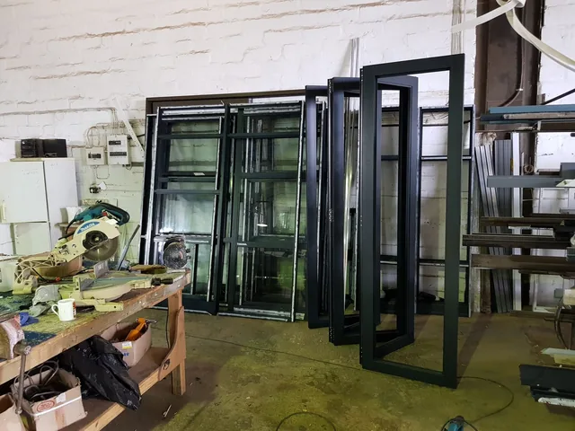 Black aluminium frame sections prepared in the workshop
