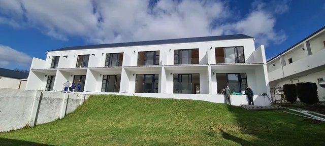 White aluminium windows and doors across a multi-unit facade
