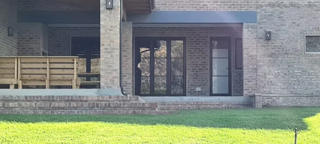 Black aluminium doors and sidelights set into a brick exterior