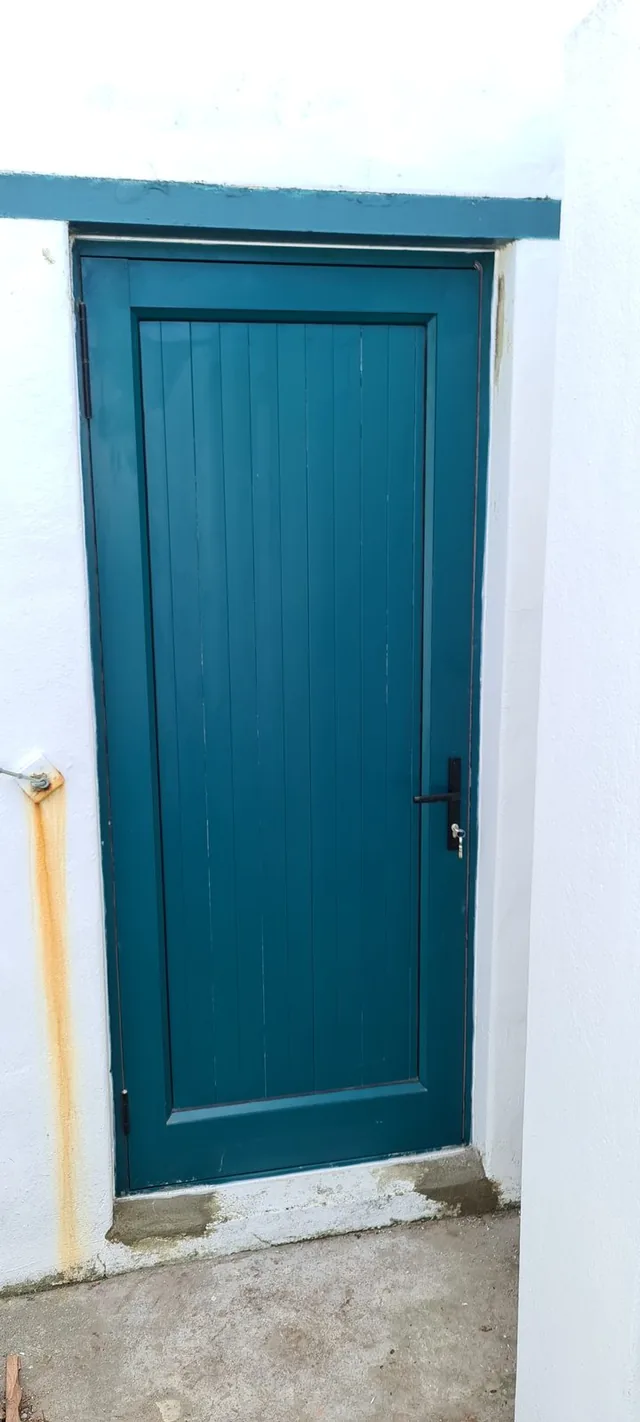 Green aluminium entrance door in a white wall