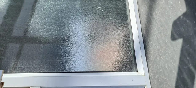 Close view of patterned privacy glass in an aluminium frame