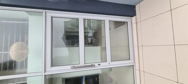White sliding aluminium window fitted into a tiled exterior